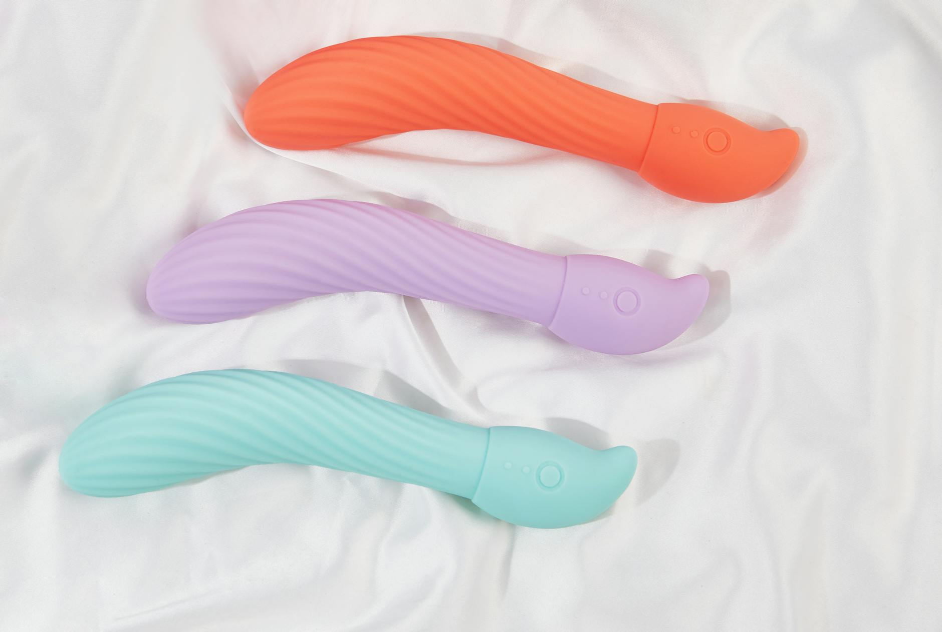 Three colorful vibrators arranged on white fabric, representing different sensations and recovery options