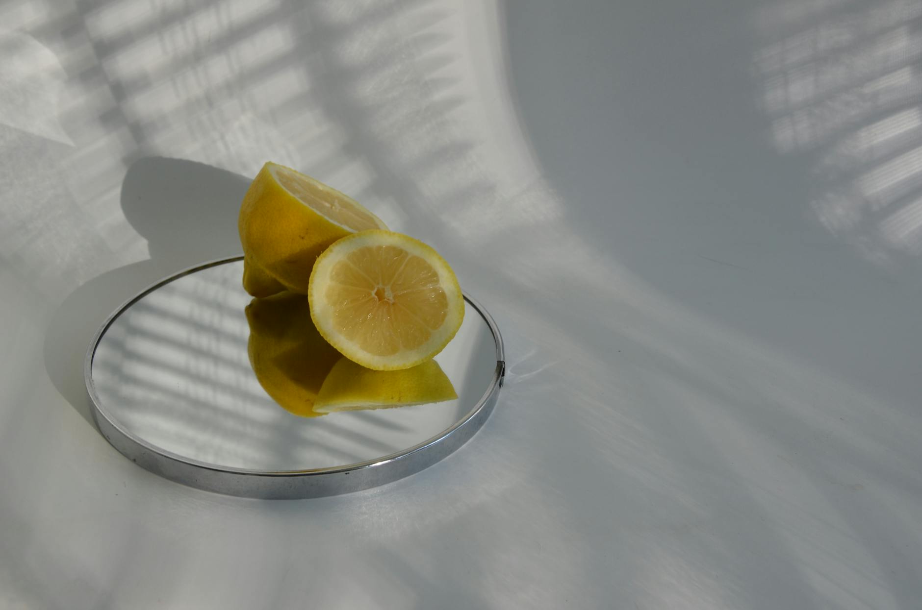 Sliced lemons on a mirror casting shadows, symbolizing mindfulness and presence during intimate moments.