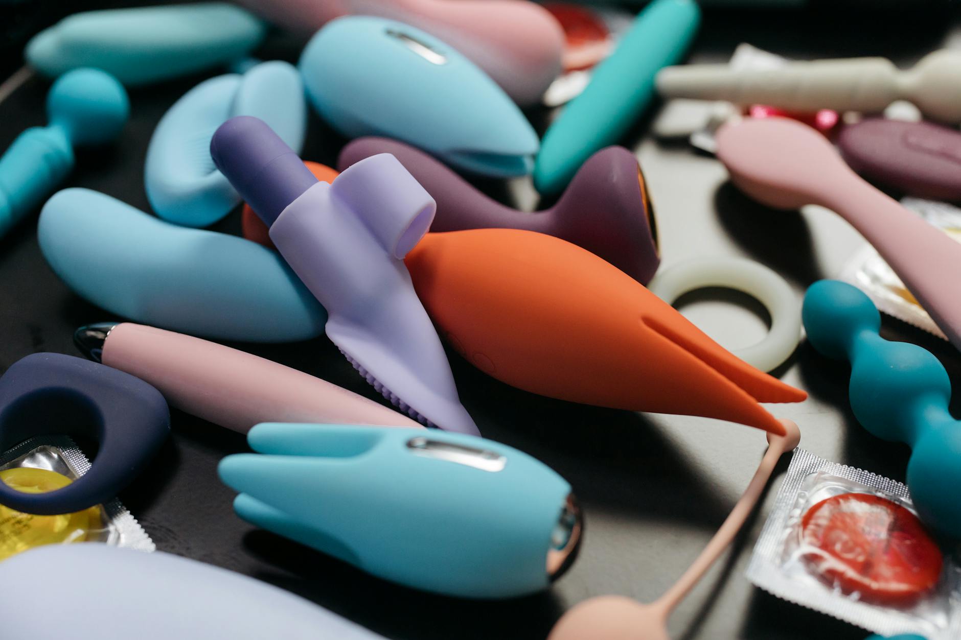 An array of vibrant adult toys including vibrators and rings displayed together